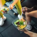 Deux personnes tenant des salades dans un gymnase