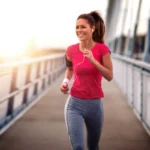 Femme avec un t-shirt rose courant sur un pont